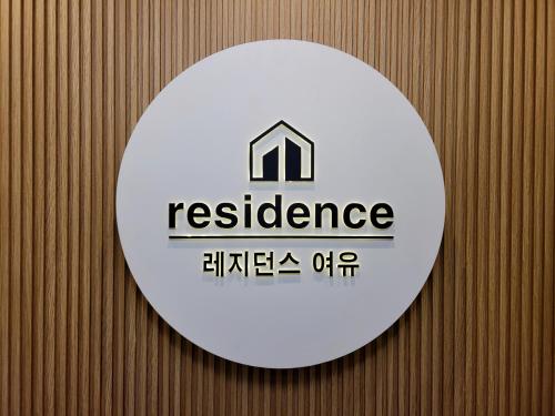 a white sign on a wooden wall with aresurance sign at Residence YeoYu in Incheon