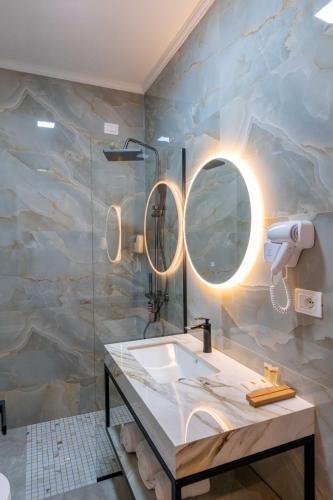 a bathroom with a sink and a mirror at Aks Hotel in Durrës