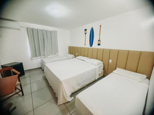 Katil atau katil-katil dalam bilik di Suiíte com ar condicionado, frigobar e mesa para trabalho. Localizada no Hotel Porto Belo Park, com parque aquático (sem custo para a utilização), quadras, academia, espaço kids, a aproximadamente 200 m praia de Taperapuã e do complexo Axé Mói.