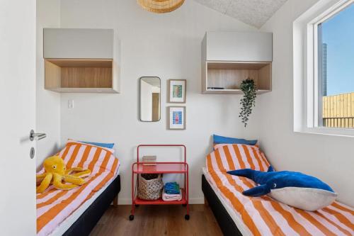 two beds in a room with a shark pillow and toys at Feriehus 1135 in Ringkøbing