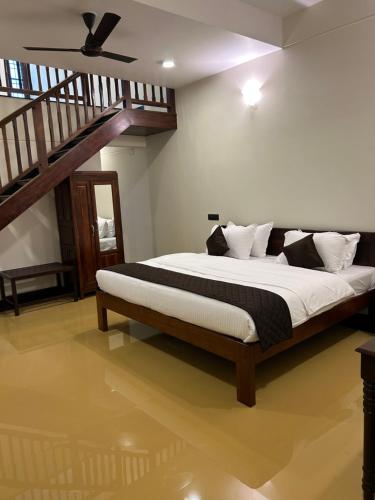 a bedroom with a large bed with a ceiling at Hotel Grand Palais in Bengaluru