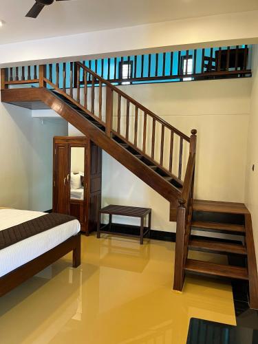 a wooden staircase in a room with a bed at Hotel Grand Palais in Bengaluru