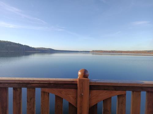 a view of a lake from a wooden railing at Domki Sosnowa Dolina in Wiele