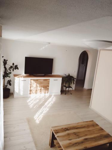 a living room with a tv and a table at Erholung in der Vulkaneifel in Kirchweiler