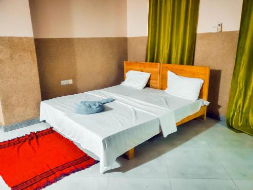 a bedroom with a bed with a blue towel on it at Stone House & Apartment 3 in Zanzibar City
