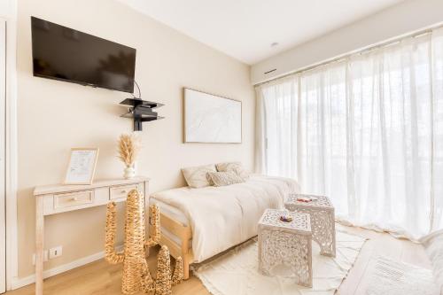 Un dormitorio blanco con una cama y un televisor de pantalla plana. en Bohemian Nuance - 15 min from Orly - Calme & Elégance, en Antony