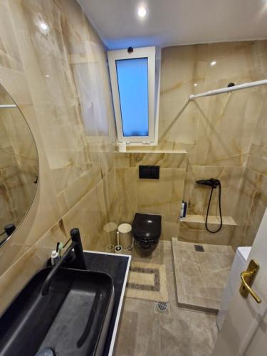 a bathroom with a sink and a toilet and a window at Relax Dream Villa-House, Apartement, Studio in Kallithea Halkidikis