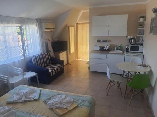 Una cocina y una sala de estar con una mesa. en Apartments Ivelin, en Lozenets