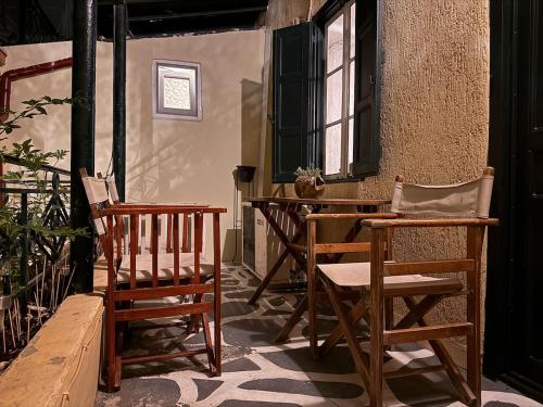 a patio with chairs and a table and a window at Pete's Guest House in Megara