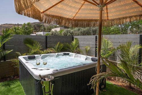a hot tub with two wine glasses and an umbrella at classic la in Mashabbe Sade