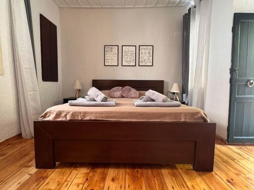 a bedroom with a large bed with two pillows on it at Pete's Guest House in Megara