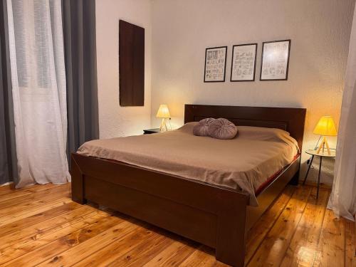 a bedroom with a bed with two lamps and two tables at Pete's Guest House in Megara