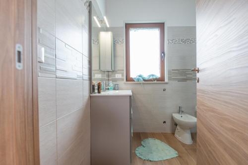 a white bathroom with a sink and a toilet at La Casa Nel Vigneto in Marina San Vito