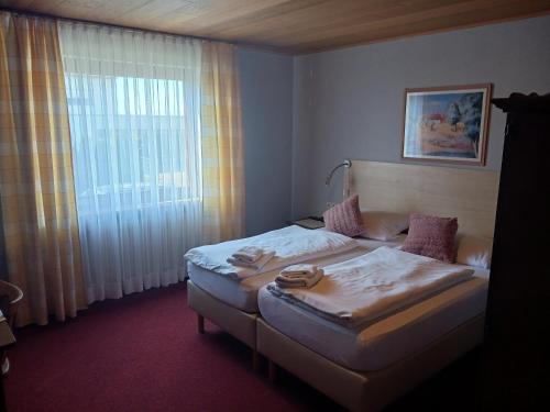 a hotel room with two beds and a window at Gasthof Pension Zum Böhlgrund GmbH in Knetzgau