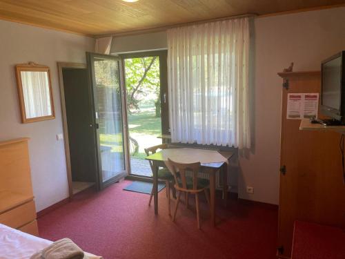 a room with a table and chairs and a room with a window at Gasthof Pension Zum Böhlgrund GmbH in Knetzgau