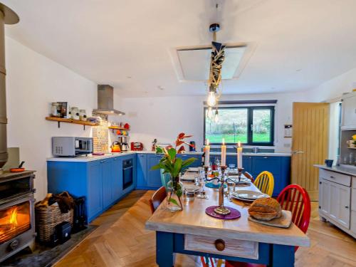 a kitchen with blue cabinets and a table with food on it at 3 Bed in Pitlochry CA207 in Struan