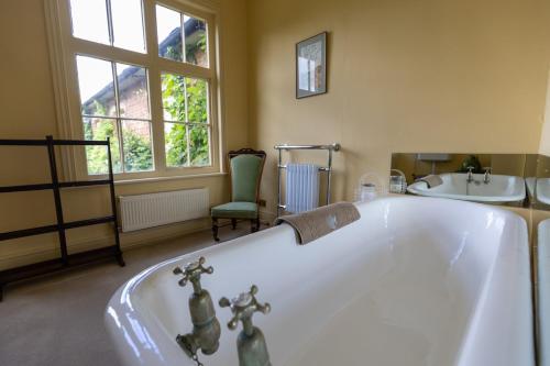 a bathroom with a bath tub and a sink at Belvoir Lodge - Sleeps 18 - Belvoir Castle in Redmile