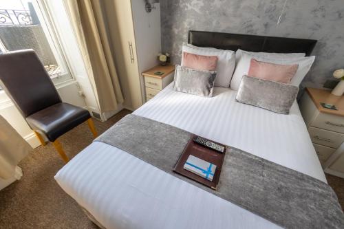 a bedroom with a bed with a desk and a chair at The Cumberland in Weymouth