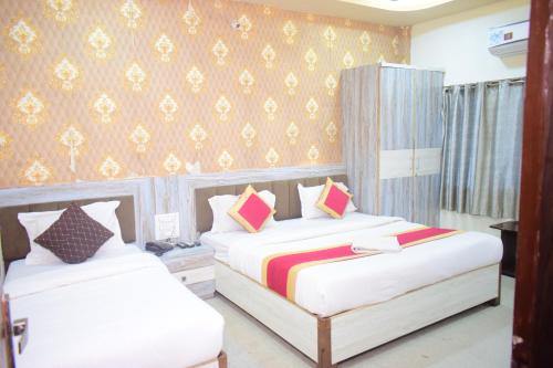 a bedroom with two beds and a wall at Vinayak shree hotel in Indore