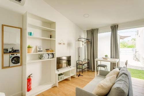 a living room with a couch and a table at Charming Aroeira Beach Studio in Aroeira