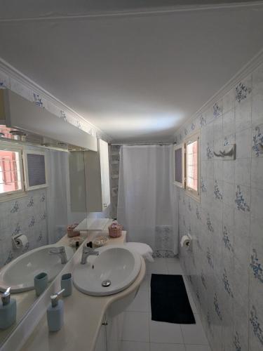 a white bathroom with a sink and a shower at Casa Carmela in Posidhonía