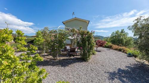 a garden with a gazebo and chairs and plants at Podere San Regolo in Scansano