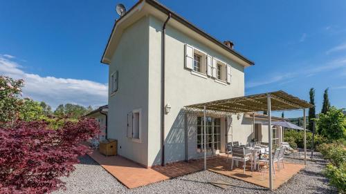 a white house with a patio and a table at Podere San Regolo in Scansano
