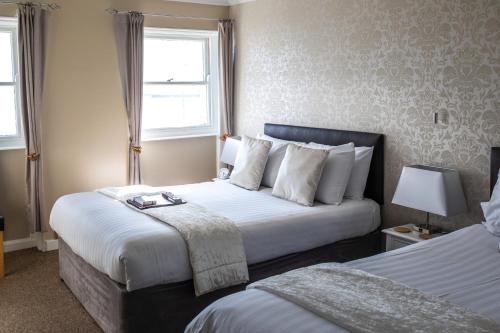 a hotel room with two beds and a window at The Cumberland in Weymouth