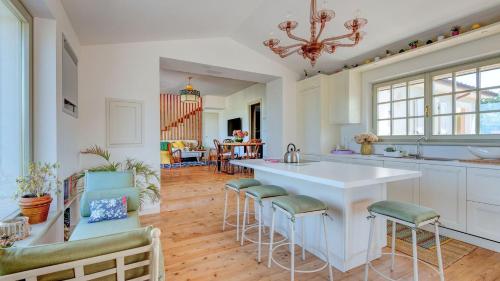 a kitchen with a large white island with bar stools at Podere San Regolo in Scansano
