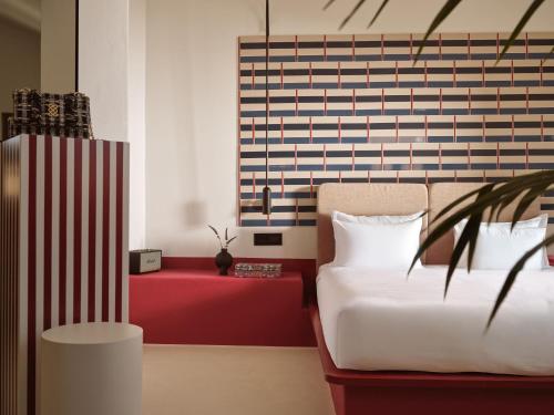 a bedroom with a bed and a red table at Neema Maison Finikia Santorini in Oia