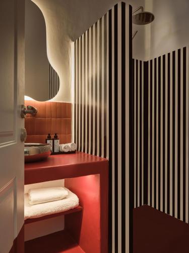 a bathroom with a red counter and a sink at Neema Maison Finikia Santorini in Oia