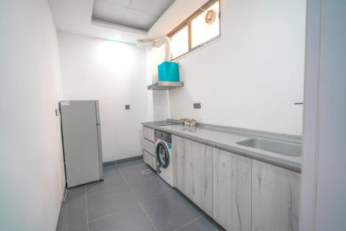 a kitchen with a sink and a washing machine at Danzha Motel Erbil in Erbil