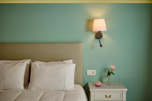 a bedroom with a bed with a lamp and a night stand at Parnassos Delphi Hotel in Delfoi