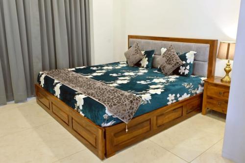 1 cama con edredón y almohadas azules en Red Stone Villa - Shimla, en Shimla
