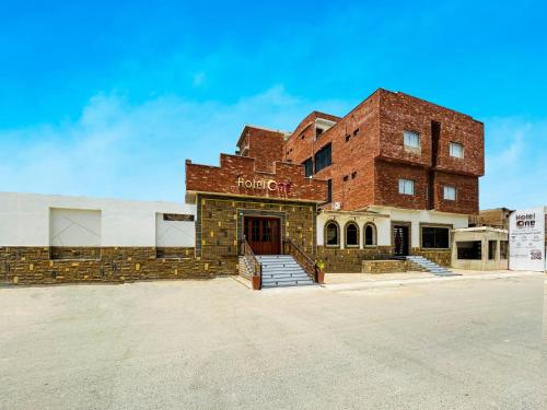 a red brick building with a sign on it at Hotel One University Sukkur in Sukkur