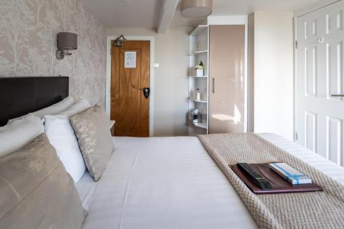 a bedroom with a bed with a tray of books on it at The Cumberland in Weymouth