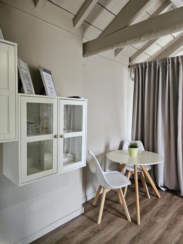 a dining room with a table and a white cabinet at Casas Sebastião - Tourist House in Caminha