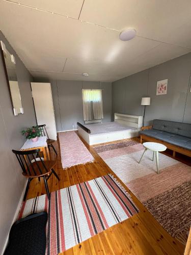 a living room with a bed and a couch at Cozy cottage on lake in Iokela
