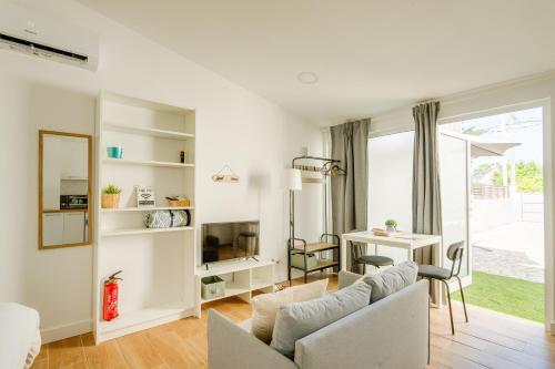 a living room with a couch and a table at Charming Aroeira Beach Studio in Aroeira