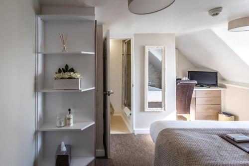 a bedroom with a bed and a tv and a window at The Cumberland in Weymouth