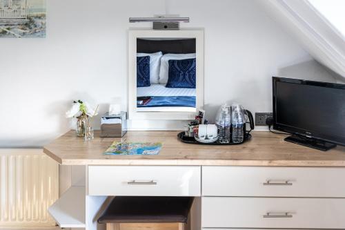 a room with a desk with a tv and a bed at The Cumberland in Weymouth