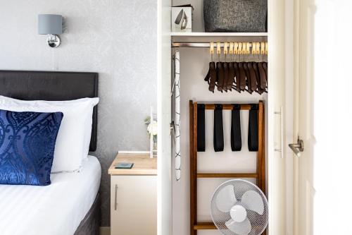 a bedroom with a bed and a closet with a fan at The Cumberland in Weymouth