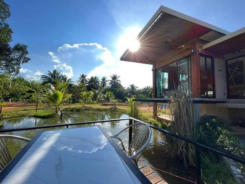a villa with a swimming pool and a house at Darisa Home in Suratthani