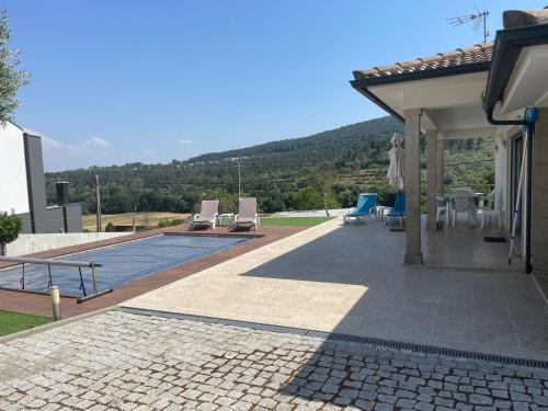 a house with a patio and a swimming pool at Campeã Valley in Campeã