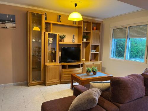 un soggiorno con un divano e una TV di Apartamentos Sardiñeiro a Fisterra (Finisterre)