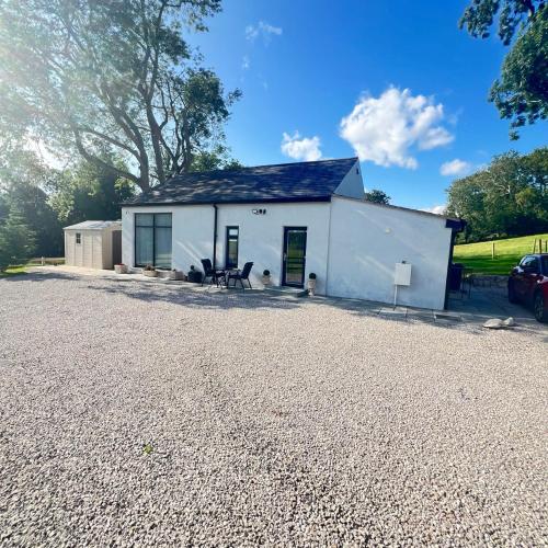 a white house with a gravel driveway at Thwaite Croft - Carnforth in Carnforth