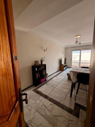 an empty living room with a table and a window at Luxury Apartment Ocean View and Private Beach Ain Diab in Casablanca