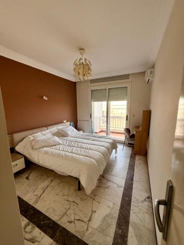a bedroom with a large bed and a chandelier at Luxury Apartment Ocean View and Private Beach Ain Diab in Casablanca