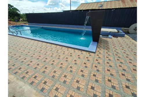 a swimming pool with a fountain in a yard at Capital O 90168 Serambi Pelangi Chalet in Changlun