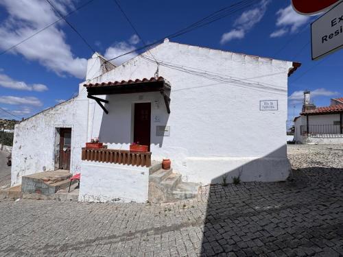 a small white building with a window and a door at Casinha do Chafariz - Casas da Amieira in Amieira